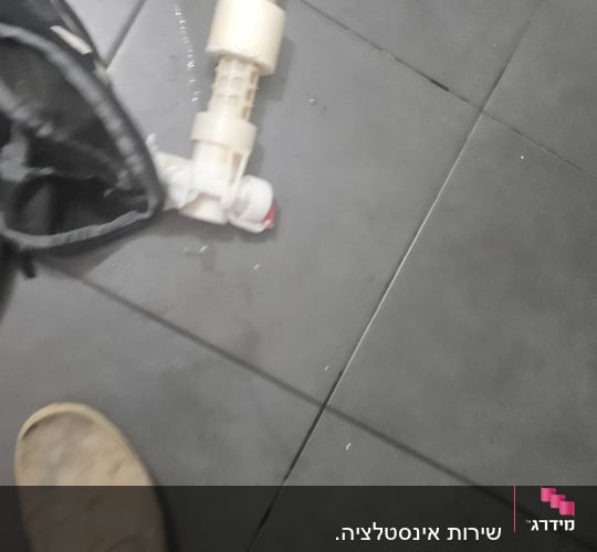 חלקי צנרת וכלי עבודה על רצפה